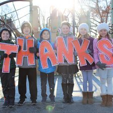 Kids holding up a "THANKS" sign